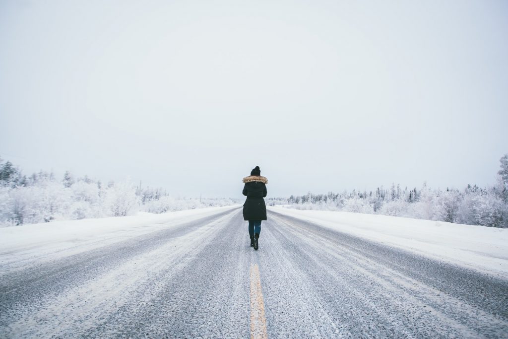 woman walking alone in the snow road