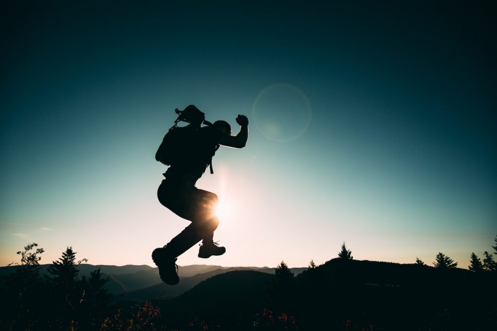 man jumping into the wild beyond