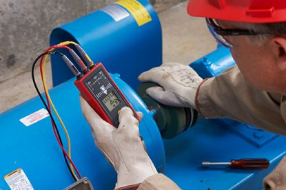 A motor rotation tester in use by a technician