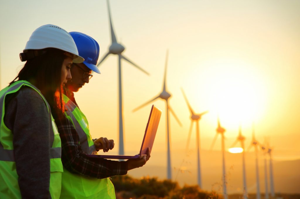 Two environmental engineers working on a field with laptop